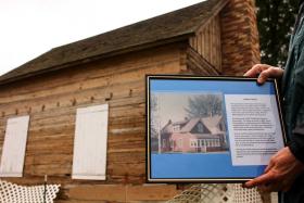 (Garrett Matteson/Brainerd Dispatch) Lynda Hall, the Assistant Administrator at the Historical Society, holds up a picture of the Carbine house from the 1960's.